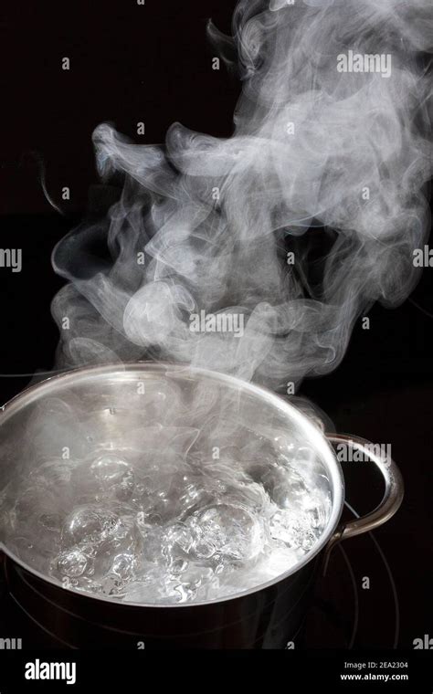 Boiling water in a saucepan, rising steam Stock Photo - Alamy