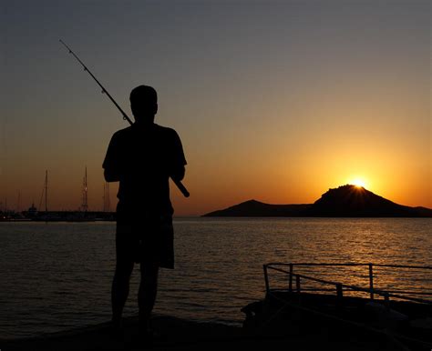 Sunset silhouette of man fishing Photograph by Paul Lemon - Pixels