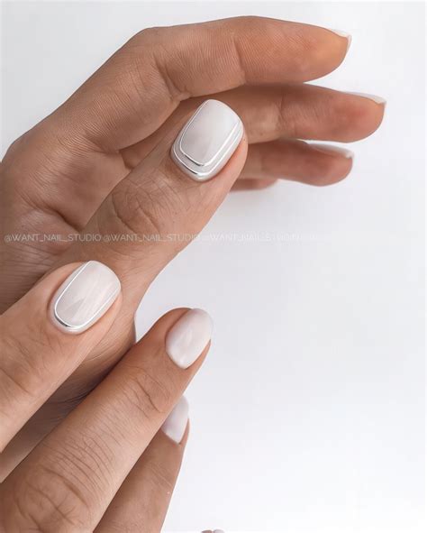 Picture Of glossy white nails with silver stripes along two nails are a ...