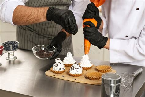 Pastry Chefs Preparing Desserts at Table in Kitchen Stock Image - Image ...