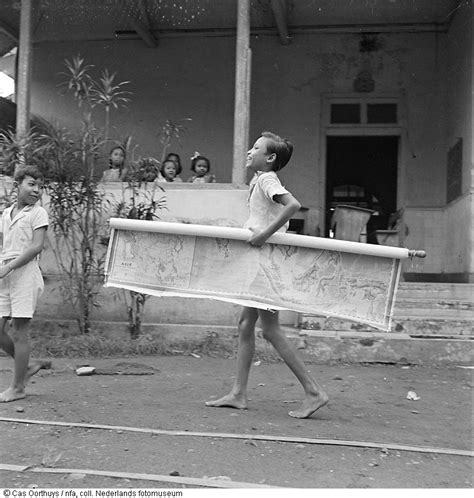 Cas Oorthuys/ Scholier loopt met een schoolplaat van het Indonesische ...