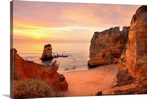 Warm sunrise seascape at Praia Dona Ana Beach in Lagos, Portugal. Wall ...