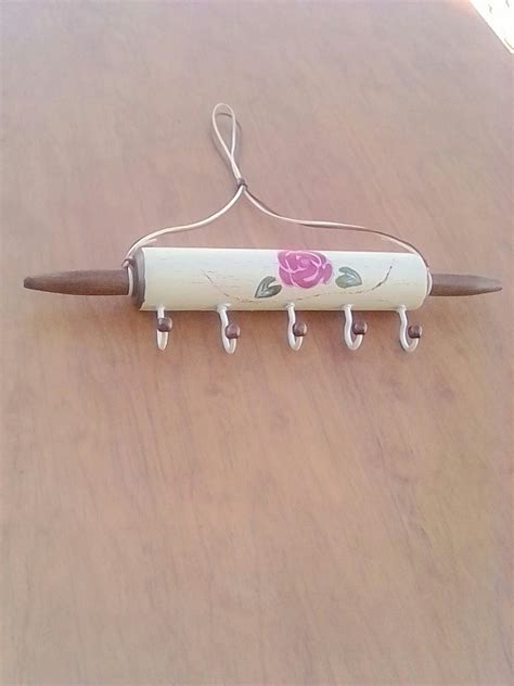 a knife hanging from a hook on a wooden table with flowers painted on ...