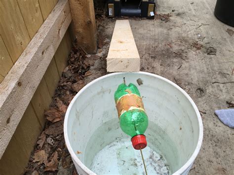 a green and red bottle in a white bucket