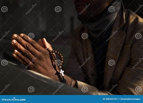 Close Up of Black Man Praying in Church with Rosary in Sunlight Stock ...