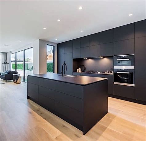 an open kitchen and living room area in a modern style home with wood ...