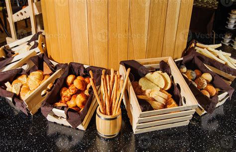 A buffet table with variety of bread in the wooden baskets 13060112 ...