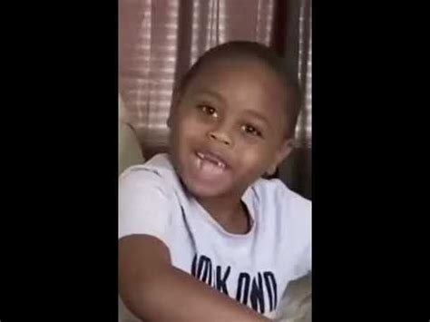 a young boy sitting on top of a couch next to a window