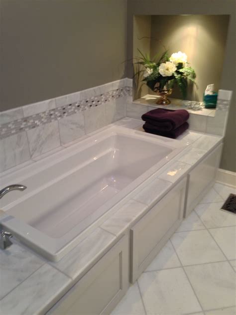 Drop in jacuzzi bath tub with tile backsplash and cabinet space ...