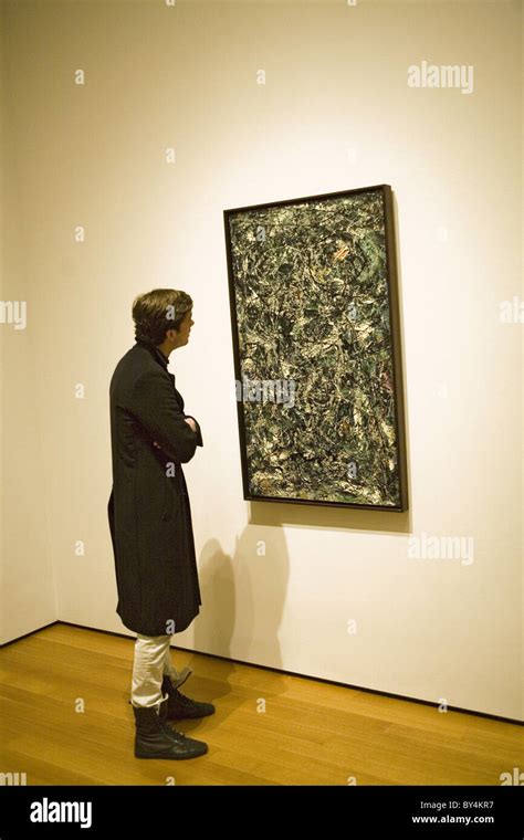 Museum visitor studies a painting by Jackson Pollock, a member of the ...