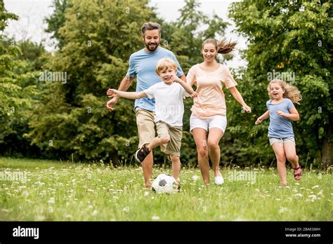 Family and children play soccer together in the garden in summer Stock ...