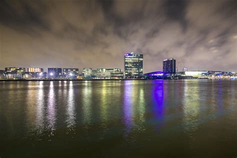 Night view over cityscape river with reflection of modern buildings ...