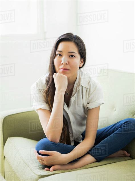 Portrait of woman sitting on sofa - Stock Photo - Dissolve