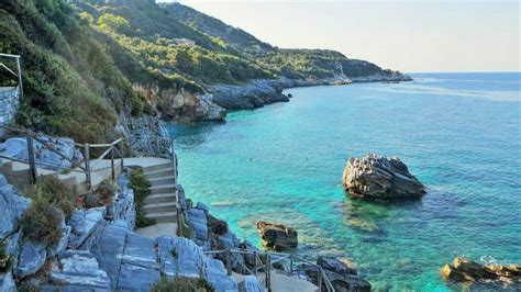 stairs lead down to the beach and into the blue water near some rocky ...