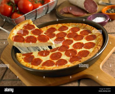 Pepperoni pizza with slice Stock Photo - Alamy