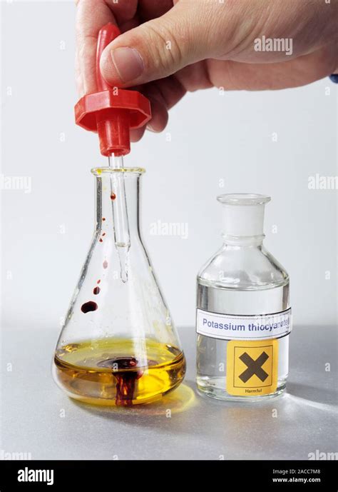 Iron test. Potassium thiocyanate solution (colourless) being added to a ...