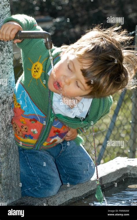 A little boy drinking from a water fountain in the park Stock Photo - Alamy