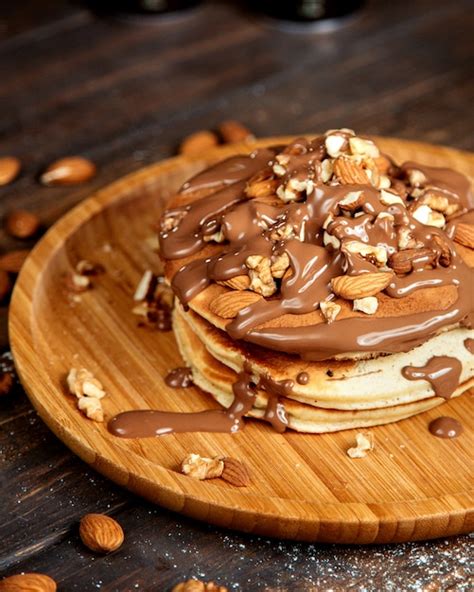 Pancakes with chocolate butter and nuts | Free Photo