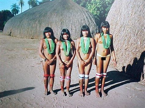 four women in bathing suits standing next to each other on the beach ...