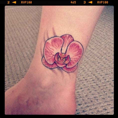 a pink flower tattoo on the ankle