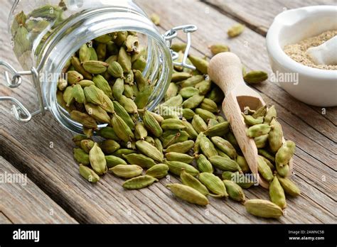 Green aromatic cardamom pods. Jar of whole cardamom pods and mortar of ...