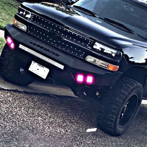 a black truck parked on the side of a road