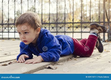 Child Laying On Ground Outside Stock Image | CartoonDealer.com #42911071