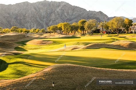 Amazing green lawn at golf course and beautiful mountains at sunny day ...