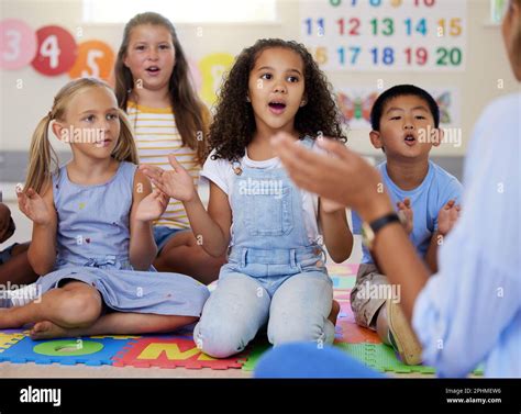 Teacher, singing or kids in classroom learning a song together in ...