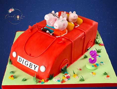 a birthday cake with peppa piggies in the back of a red car on top of ...