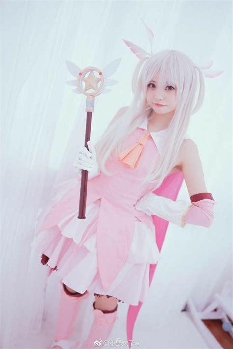 a woman dressed in pink and white holding a wand