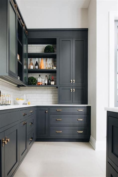 Black shaker kitchen cabinets adorned with vintage brass hardware and a ...