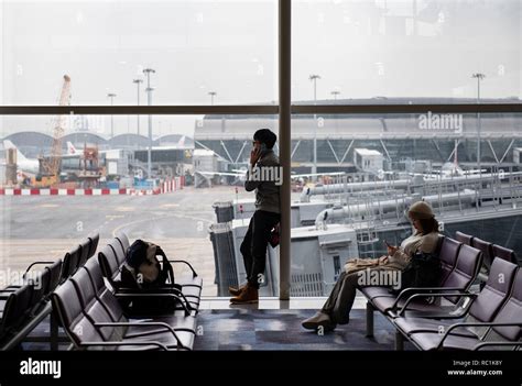 Passengers sitting in waiting area at a boarding gate at Hong Kong ...