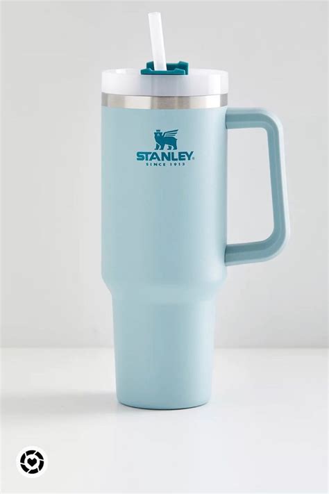 a light blue travel mug with a straw in the cup and stanley logo on it