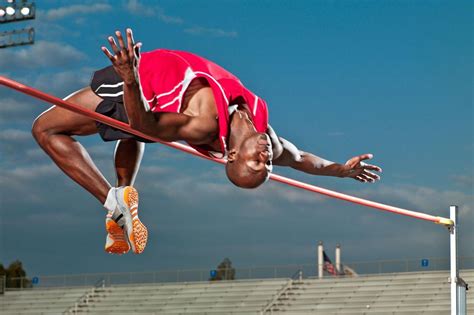 a man jumping high in the air over a pole