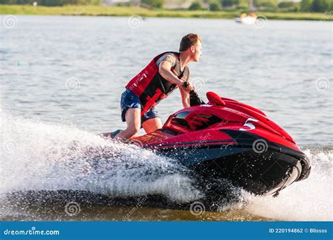 Jet Ski Watercraft Driver on Water Bike Splashing at Sunset by River ...