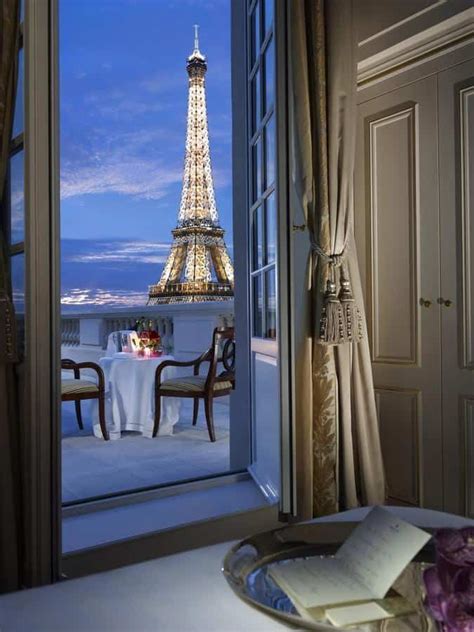 the eiffel tower is lit up at night as seen from an open window