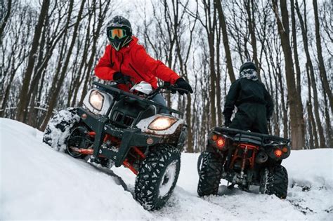 Premium Photo | On the off road two people are riding atv in the winter ...