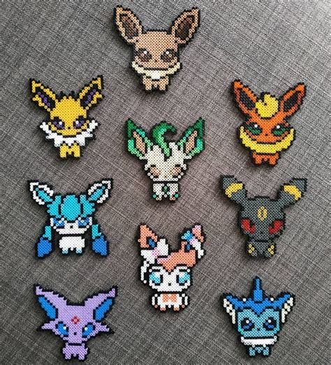 six pixelated pokemon pins sitting on top of a gray cloth covered table ...