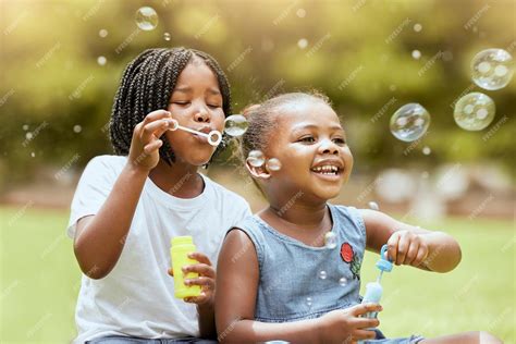 Premium Photo | Black kids children and blowing bubbles at park having ...