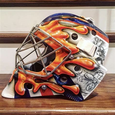 a hockey goalie's helmet with flames painted on it