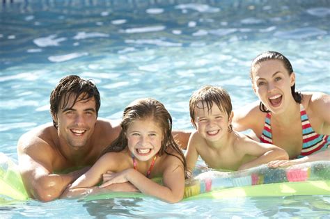 Young Family Relaxing In Swimming Pool - Rising Sun Pools and Spas