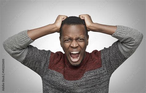 Mad African American man shouting with mouth wide open and closed eyes ...