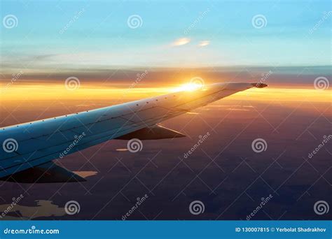 Airplane Wing in Flight at Sunrise with Sky, Clouds on the Background ...