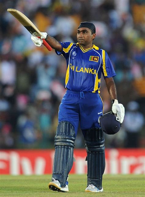 a man in blue and yellow uniform holding a bat on top of a field with ...