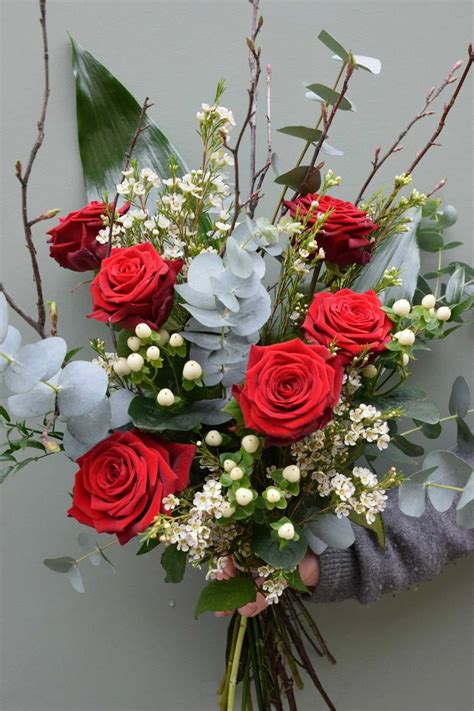 Download A Woman Holding A Bouquet Of Red Roses And Greenery ...