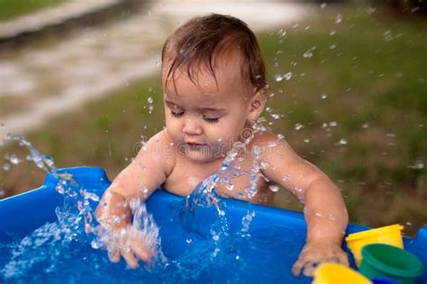 Baby Playing and Splashing in Water Outdoors Stock Image - Image of ...