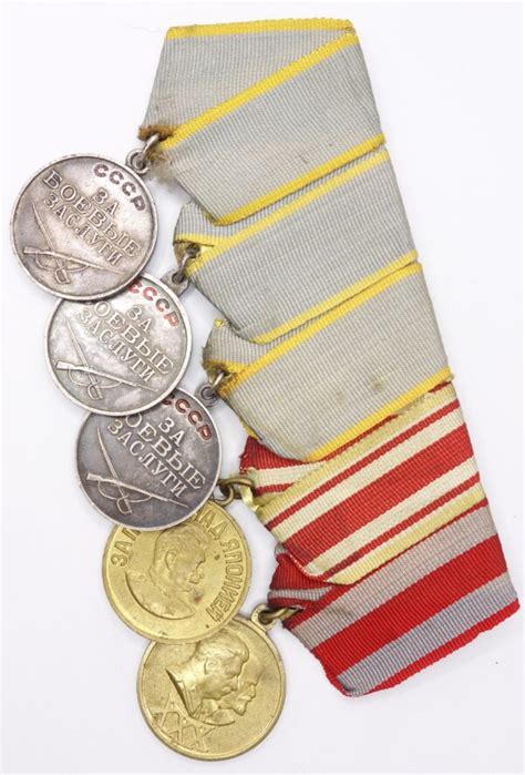 Group of Soviet medals consisting of 3 medals for Combat Merit, Medal ...