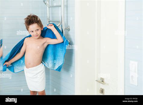 happy healthy little kid dry off his body with blue towel indoors ...