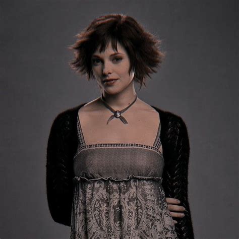 a woman with short hair wearing a dress and black cardigan over her ...